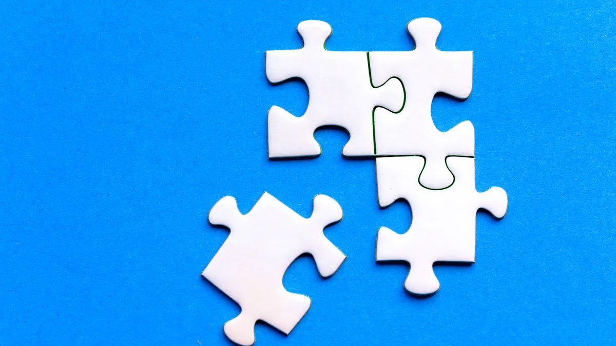 white jigsaw pieces partly assembled on blue background